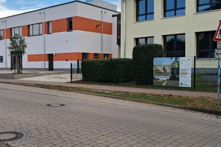 Möser © Giebelmann aufjepasst-Banner in Möser an einer Schule warnt vor zu schnellem Fahren und wirbt für Rücksicht im Straßenverkehr.