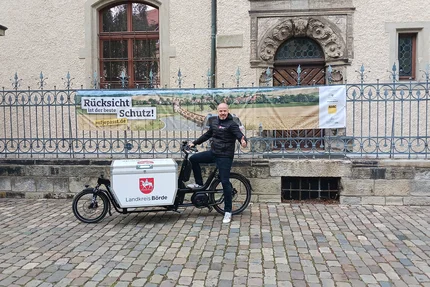 Landkreis Börde © Landkreis Börde Lastenrad des Landkreises Börde steht vor aufjepasst-Banner „Rücksicht ist der beste Schutz“.