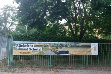 Sportsekundarschule © Katrin Kaiser aufjepasst-Banner „Rücksicht ist der beste Schutz“ am Zaun der Sportsekundarschule.