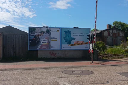 Bernburg © AGFK LSA aufjepasst-Plakat in Bernburg am Bahnübergang erinnert mit Giraffenmotiv an Schulterblick beim Spurwechsel.