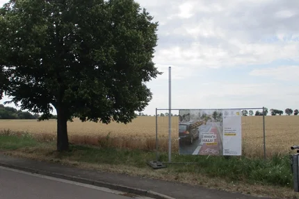 Drosa © Gemeinde Osternienburger Land aufjepasst-Verkehrssicherheitsbanner in Drosa steht am Feldrand und ruft zu Schulterblick beim Spurwechsel auf.