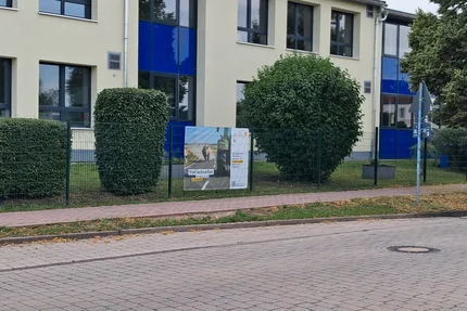 Möser © Giebelmann aufjepasst-Kampagnenbanner in Möser vor einem Schulgebäude macht auf Geschwindigkeit und Sicherheit im Verkehr aufmerksam.