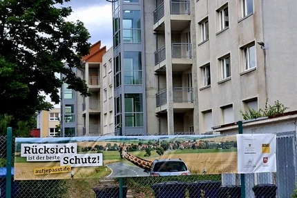 Landkreis Börde © Landkreis Börde - KVHS Wolmirstedt Schwimmbadstr. Banner „Rücksicht ist der beste Schutz“ an einem Zaun vor einem Wohngebäude in Wolmirstedt.