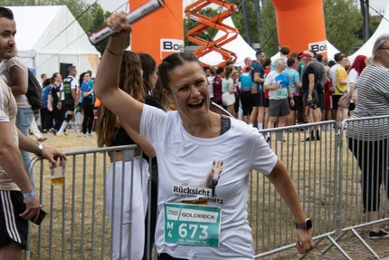 Firmenstaffel MD © Sandra Pieper Läuferin der Magdeburger Firmenstaffel mit Staffelstab und aufjepasst-Shirt „Rücksicht ist der beste Schutz“.