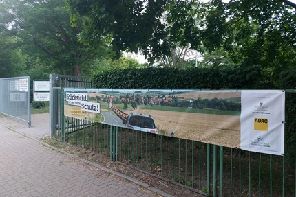 Sportsekundarschule © Katrin Kaiser Kampagnenbanner an der Sportsekundarschule zeigt Giraffe und Auto als Appell für Rücksicht im Straßenverkehr.