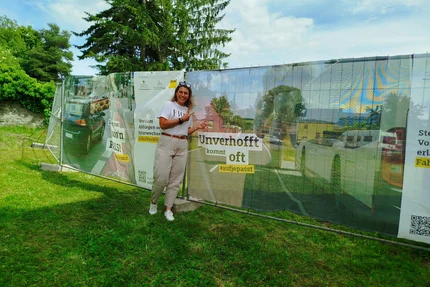 Erxleben © MID Frau präsentiert aufjepasst-Verkehrssicherheitsbanner in Erxleben zu Schulterblick und Rücksicht an Bussen.