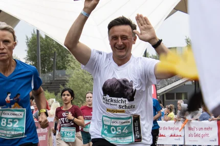 Firmenstaffel MD © Sandra Pieper Läufer der Magdeburger Firmenstaffel mit Staffelstab und aufjepasst-Shirt „Rücksicht ist der beste Schutz“.