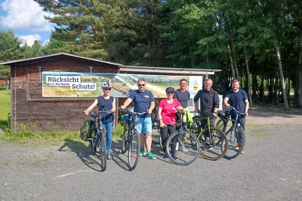 Muldestausee © AGFK LSA Radfahrende am Muldestausee stehen vor aufjepasst-Banner und setzen ein Zeichen für sicheren Radverkehr.