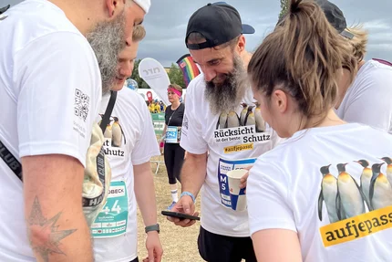 Firmenstaffel MD © buff.rocks GmbH aufjepasst-Laufteam bei der Firmenstaffel bespricht sich vor dem Start in weißen Verkehrssicherheits-Shirts.
