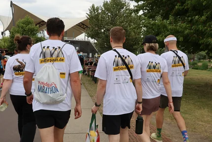 Firmenstaffel MD © buff.rocks GmbH aufjepasst-Team läuft in Kampagnen-Shirts über das Veranstaltungsgelände der Magdeburger Firmenstaffel.